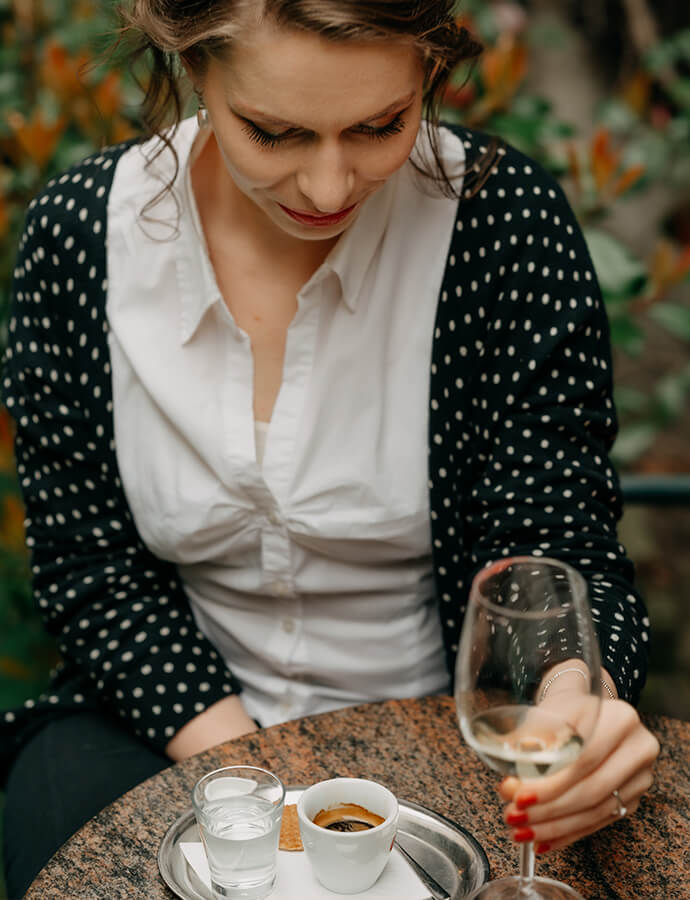 žena se skleničkou vína ve vinárně